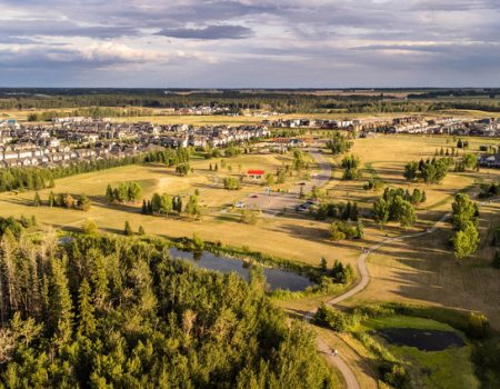 Aerial view of residential neighborhood and green spaces.